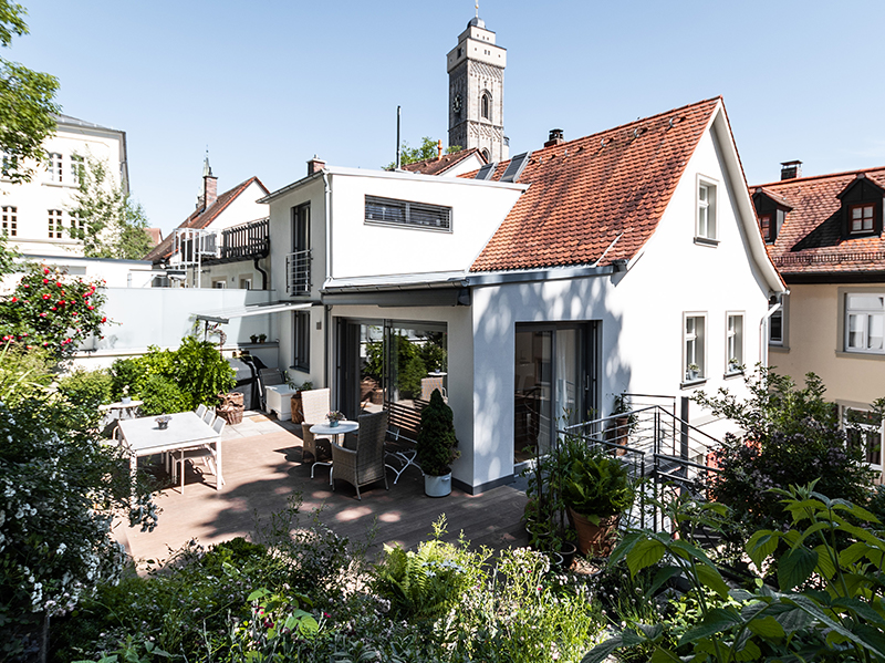 Modernisierte Altbauvilla mit roten Dachziegeln, weißer Fassade und großzügigem Garten.