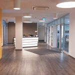 Moderner Büro- und Wohnkomplex mit offenem Empfangsbereich und heller Beleuchtung.