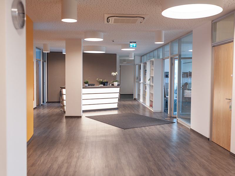 Moderner Büro- und Wohnkomplex mit offenem Empfangsbereich und heller Beleuchtung.